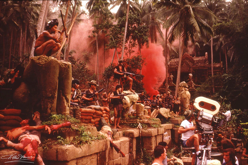Red smoke over the jungle temple set with extras and the film camera, signed Apocalypse Now behind-the-scenes photo by Vittorio Storaro